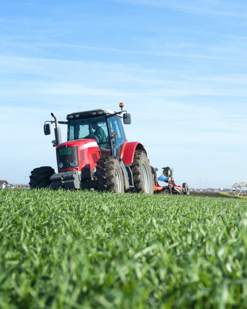 Agriculture and food production concept with tractor machine silos and irrigation system.